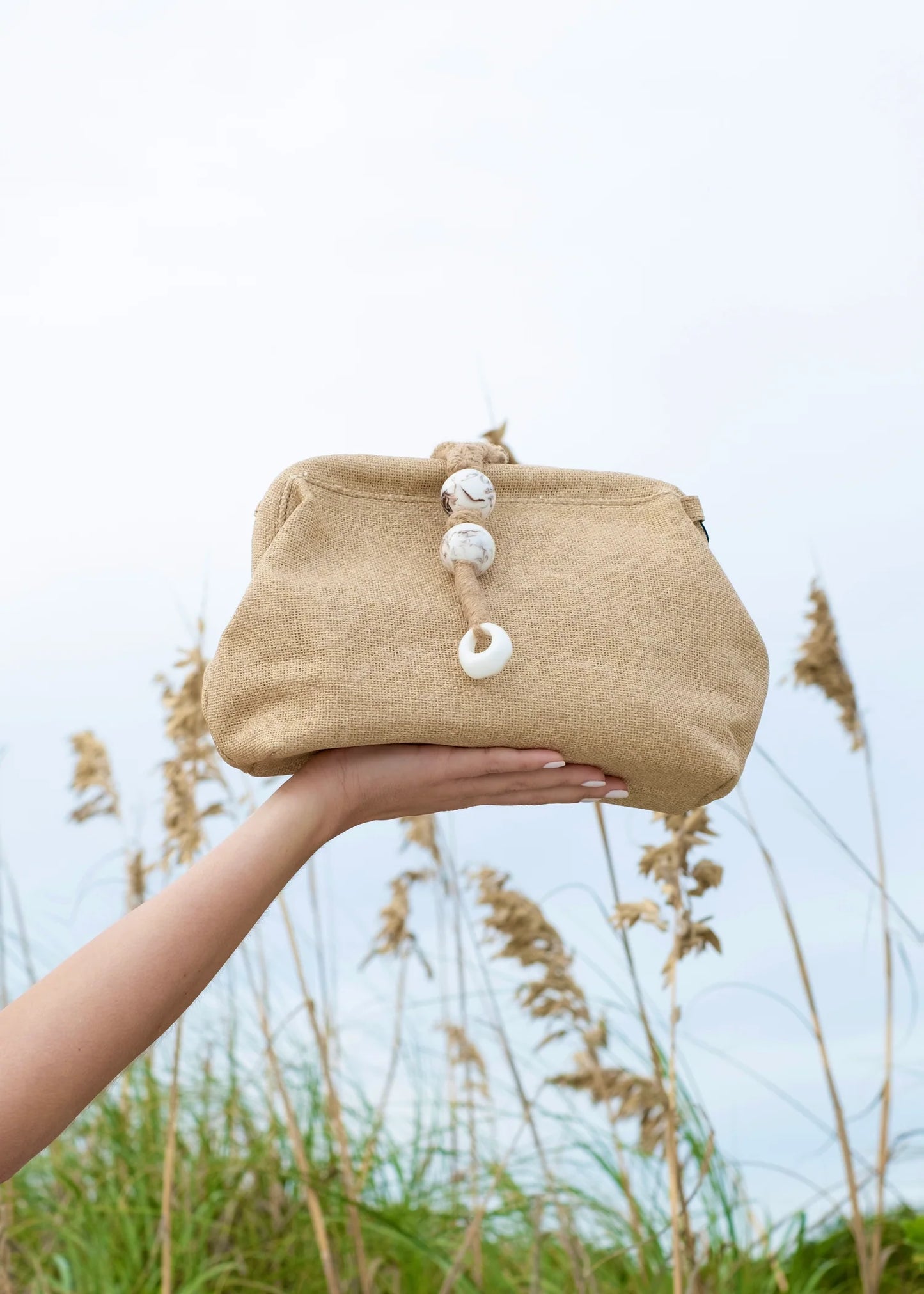 BC HANDBAG WOVEN CLUTCH – A NATURAL BEIGE CLUTCH WITH ROPE TIE DETAIL AND TEXTURED FINISH