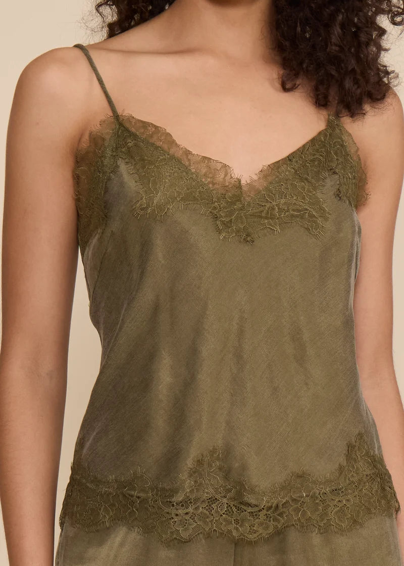 An olive green sheer camisole top with delicate lace trim along the neckline and hem, shown on a model against a warm beige background.
